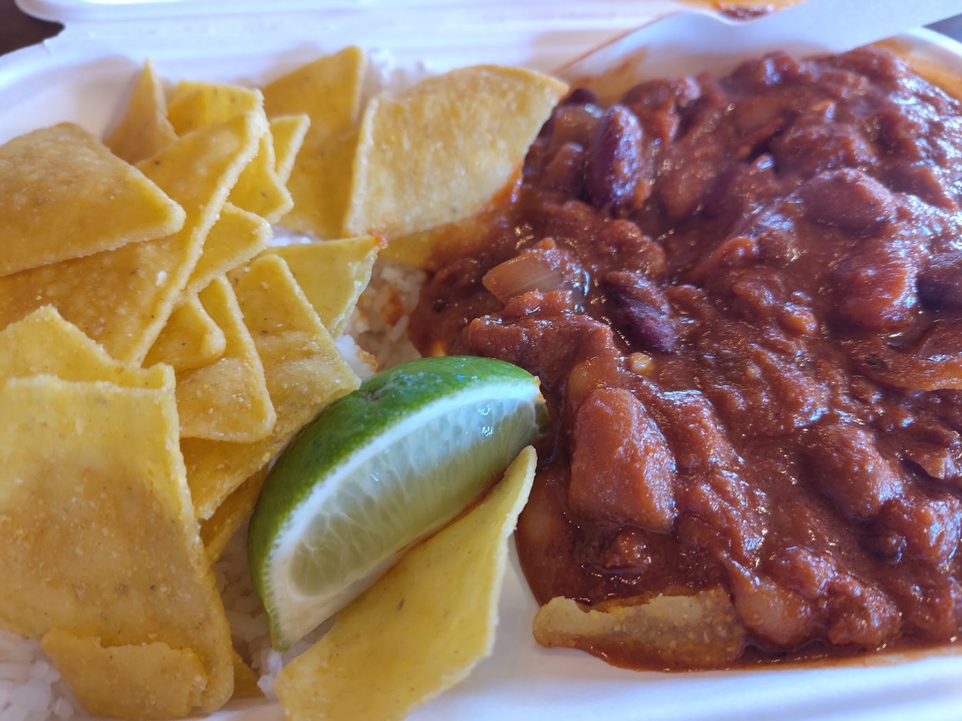 Chilli with tortilla chips and a lime wedge