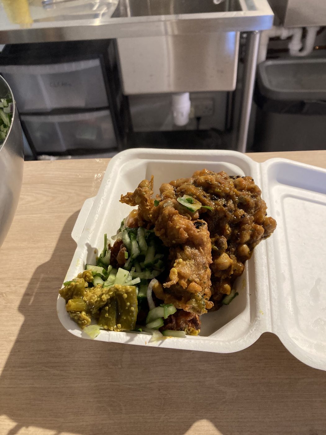 Curry with salad in a takeaway box