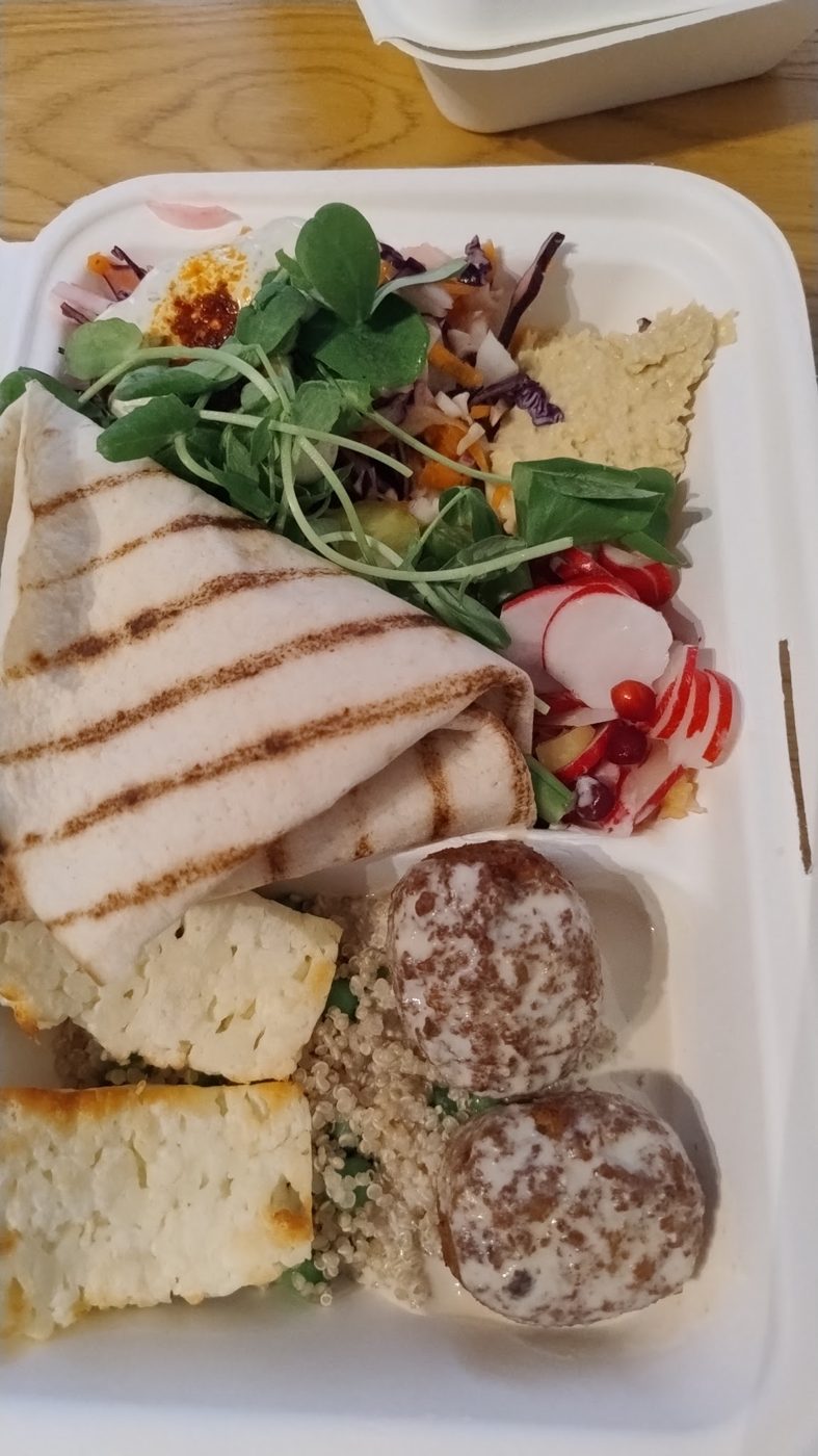 Grilled halloumi, falafel and salad in a takeaway box