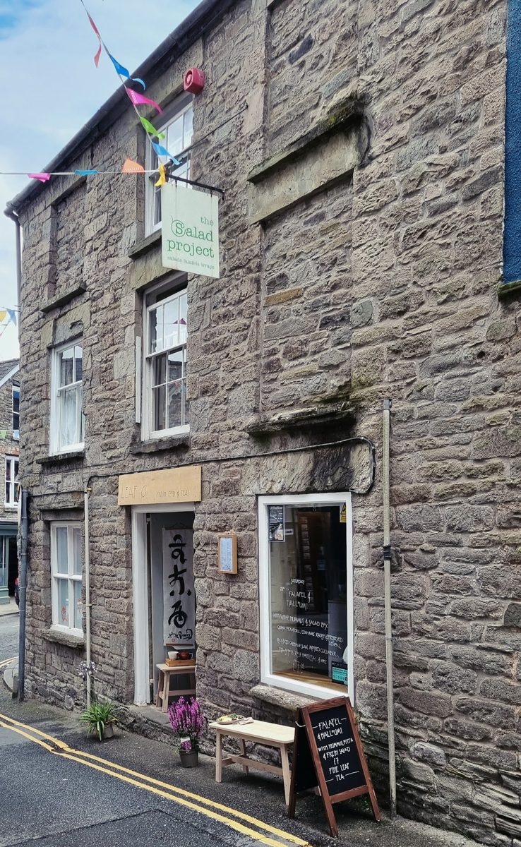 The stone-fronted shop with a hanging The Salad Project sign, bunting and a chalkboard outside